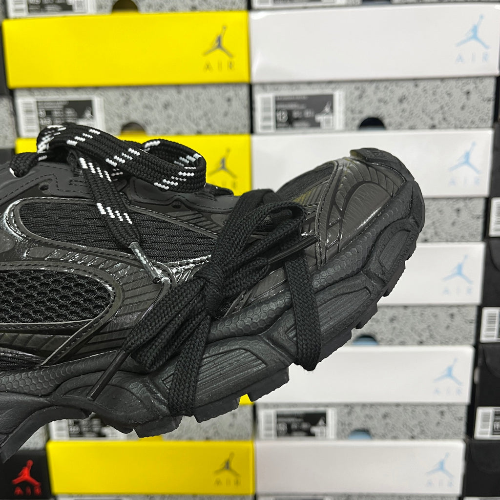 Black sneakers showing side profile, textured upper, and padded heel