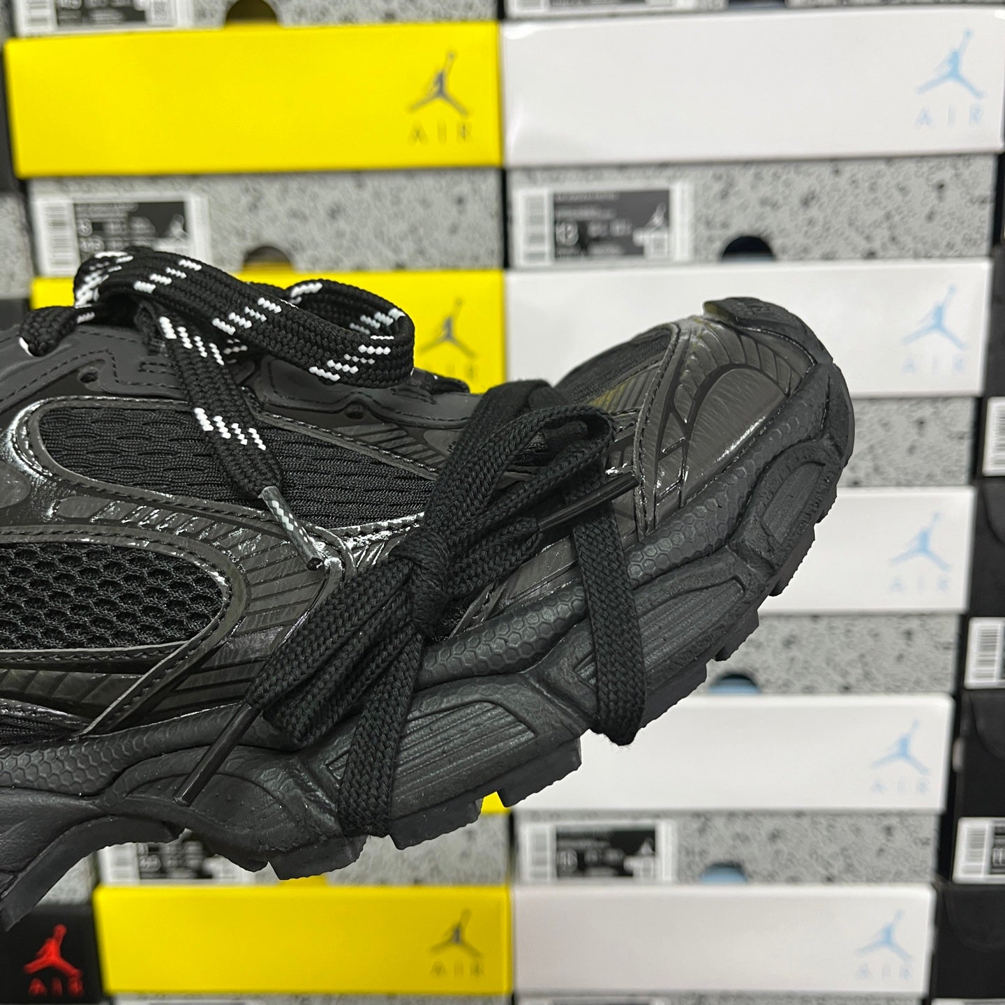Black sneakers showing side profile, textured upper, and padded heel