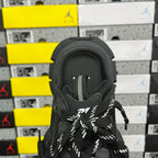 Black sneaker tongue and laces with small logo patch at center