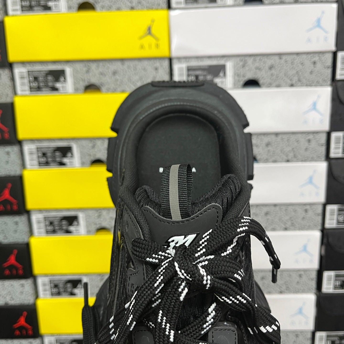 Black sneaker tongue and laces with small logo patch at center