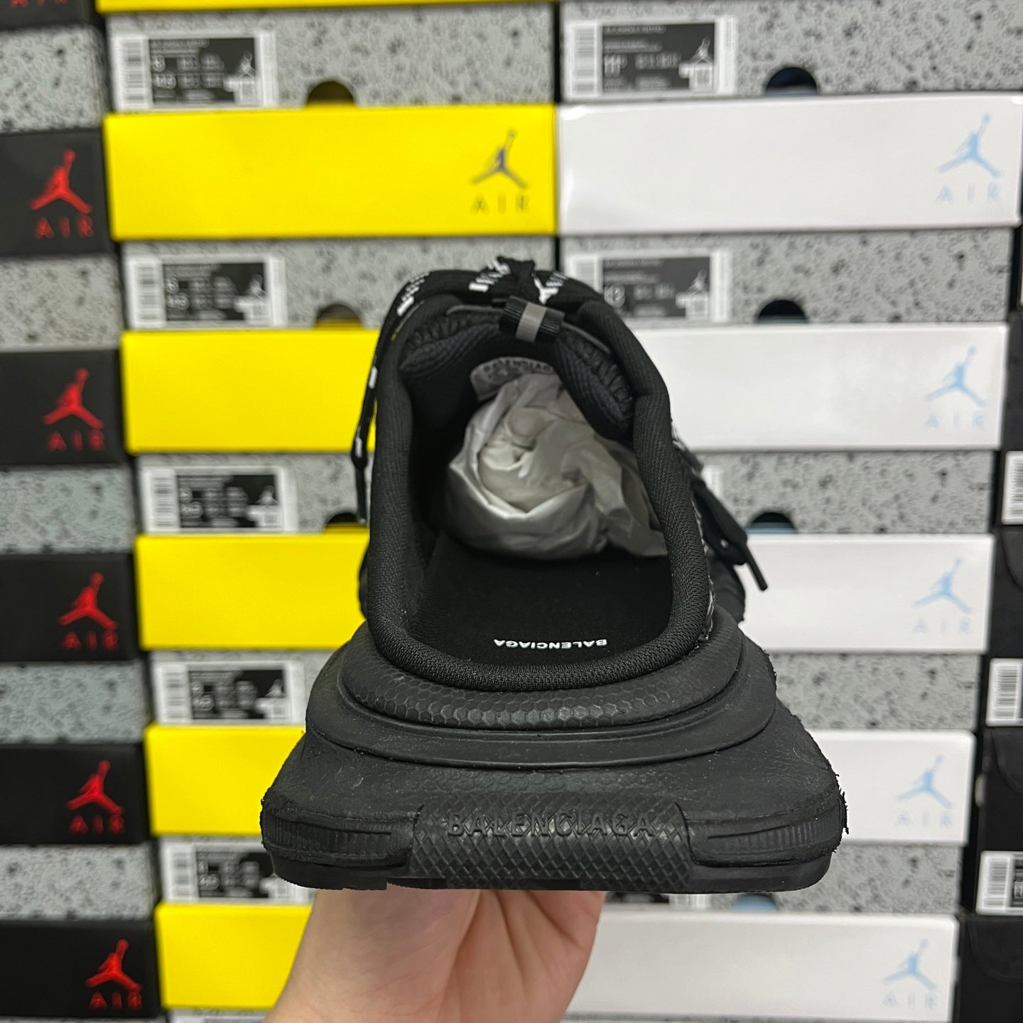 Black sneakers viewed from the heel with padded collar and lace ties