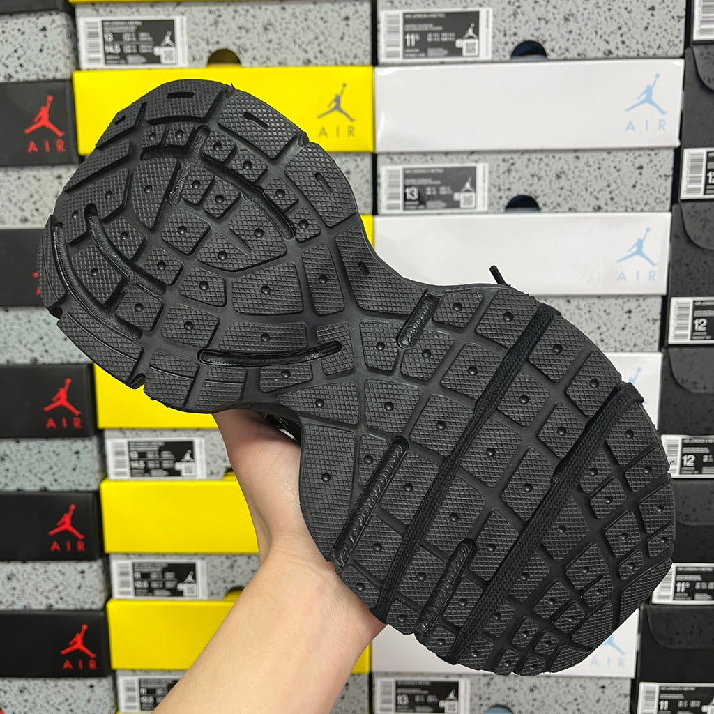 Black rubber outsole with tread pattern and traction lugs for athletic use