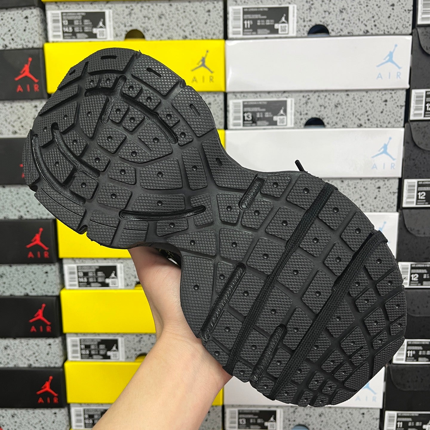 Black rubber outsole with tread pattern and traction lugs for athletic use