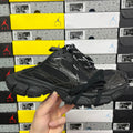 Black athletic sneakers with textured panels, lace-up front, and thick rubber sole