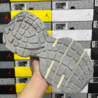 Light gray sneaker outsole with raised grid tread and pale yellow-green stripe.