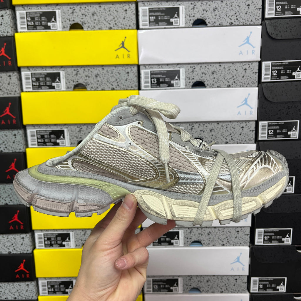Light gray lace-up sneaker with mesh panels, strappy overlays, and sage green sole.
