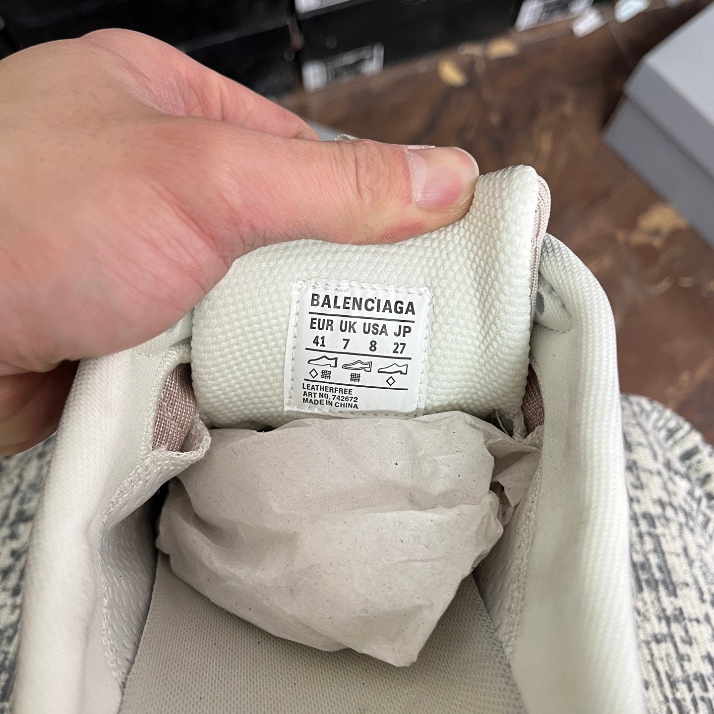 Light gray sneaker tongue label marked Balenciaga and size options, lace-up opening.