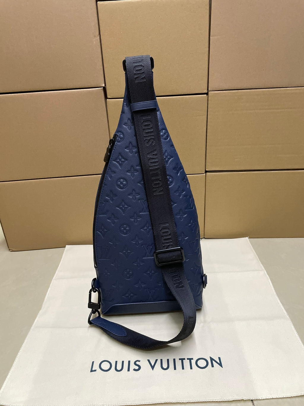 Blue monogram sling bag with adjustable strap and side zipper pocket