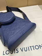 Blue monogram bag close-up with curved handle and stitched leather trim