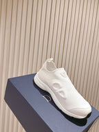 White slip-on sneaker on a blue box, side view with chunky sole and Dior logo