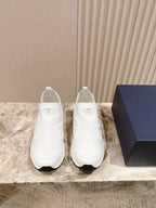 White slip-on sneakers, front view of a pair with cushioned collars