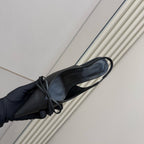 Black pointed-toe slingback heels with lace ties, angled side view