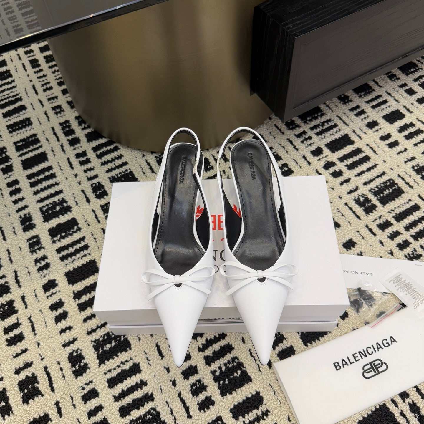 White pointed-toe slingback heels with bow detail