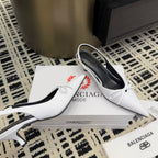 White pointed-toe heels with bow straps and black interior
