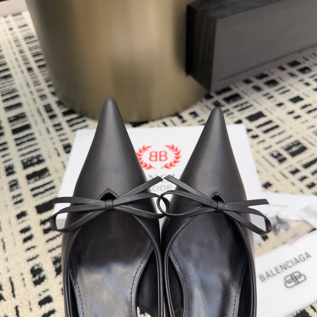 Pair of black pointed-toe lace-up heels with bow ties and stiletto heels