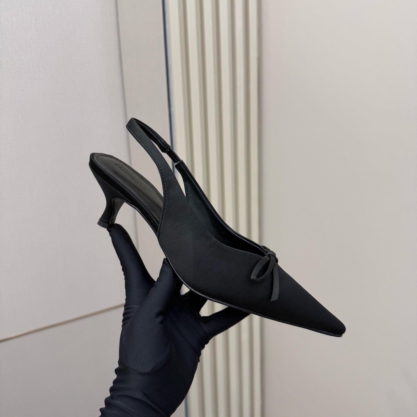 Women's black slingback pointed toe heels with bow, side angle