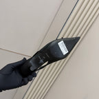 Women's black shoe underside with sole markings and barcode label