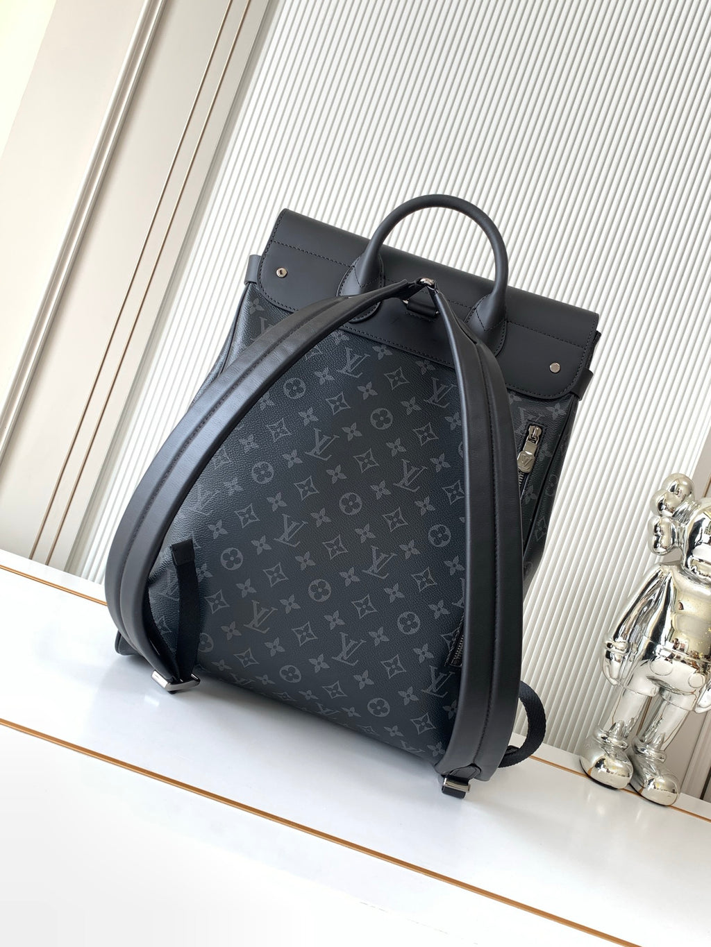 Louis Vuitton bag in dark monogram canvas with curved top handle and adjustable shoulder strap