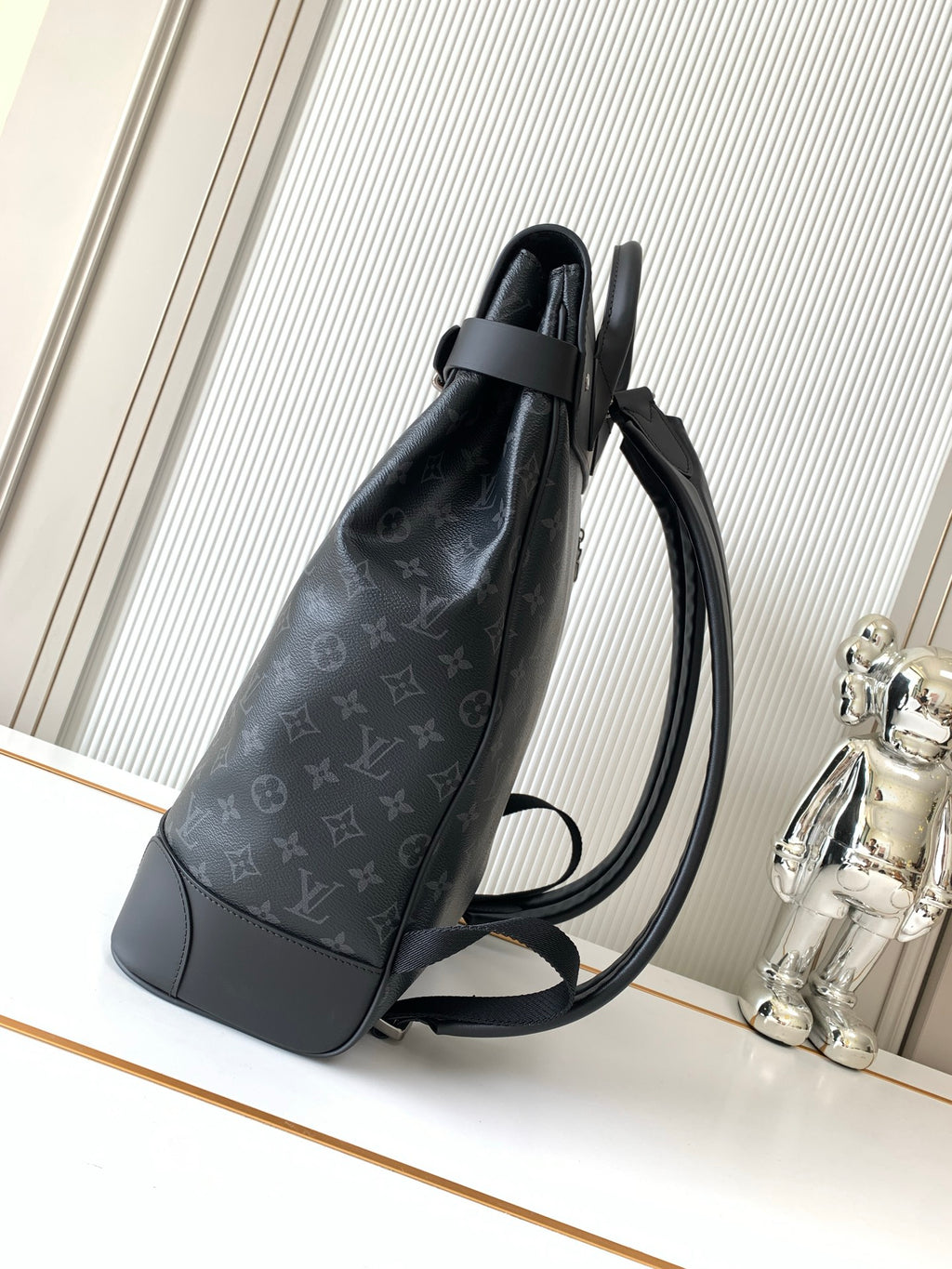 Louis Vuitton men's monogram backpack side view with adjustable shoulder strap