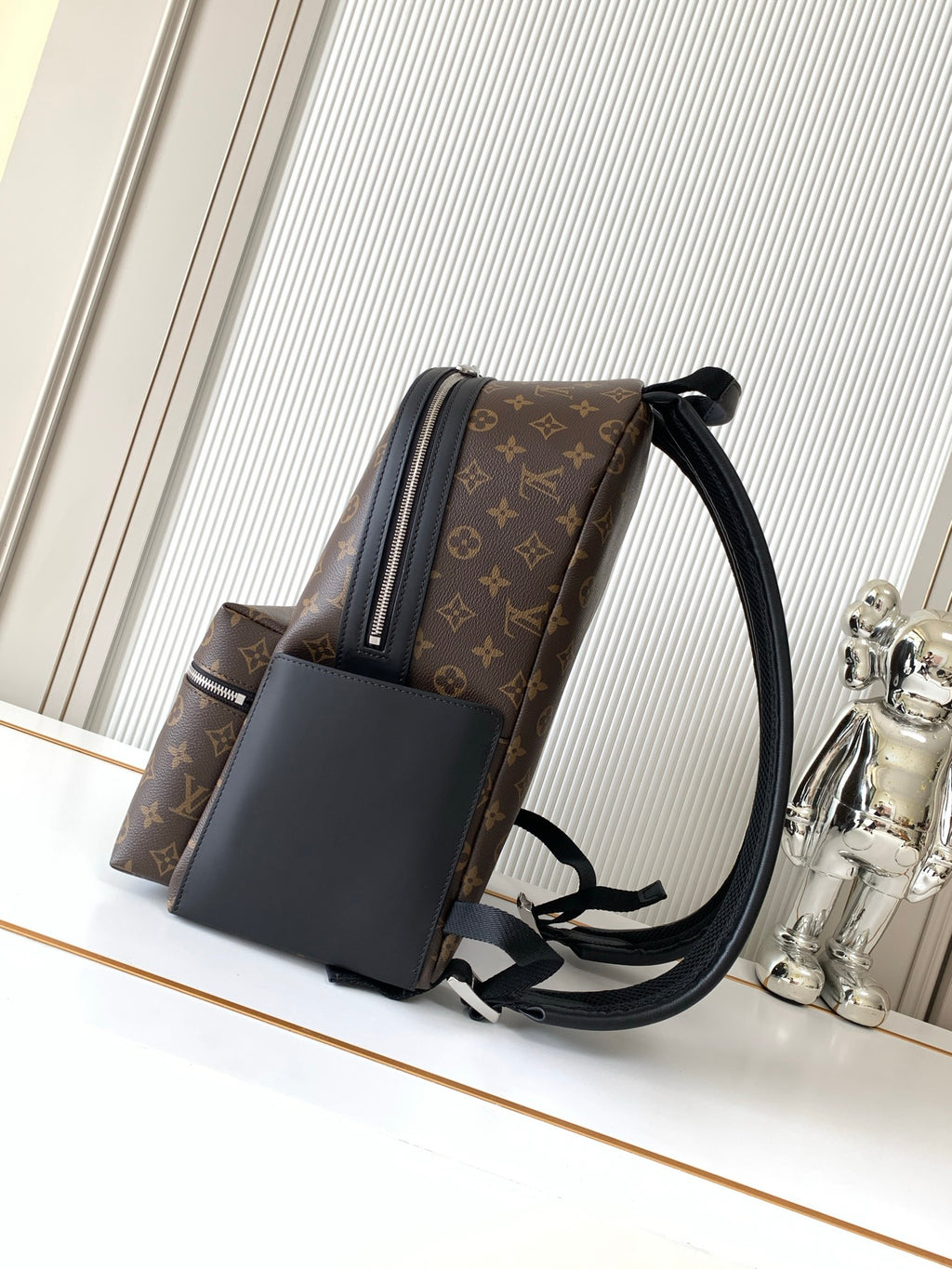 Monogram canvas backpack with adjustable shoulder straps and dark leather side panel