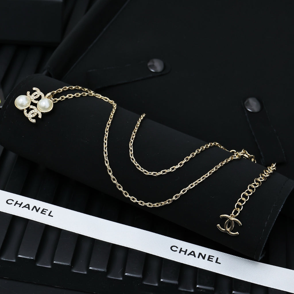 Chanel gold-tone layered necklace with pearl bow charm and logo detail