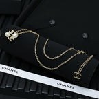 Chanel gold-tone layered necklace with pearl bow charm and logo detail