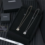 Chanel silver-tone pendant necklaces on a display card, multiple chain lengths