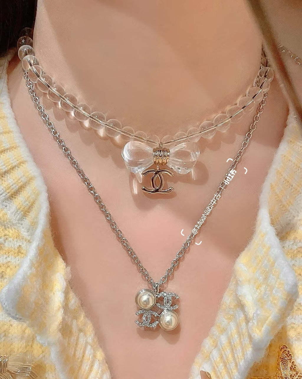 Chanel silver-tone layered pendant necklace with bow and flower charms, on neckline