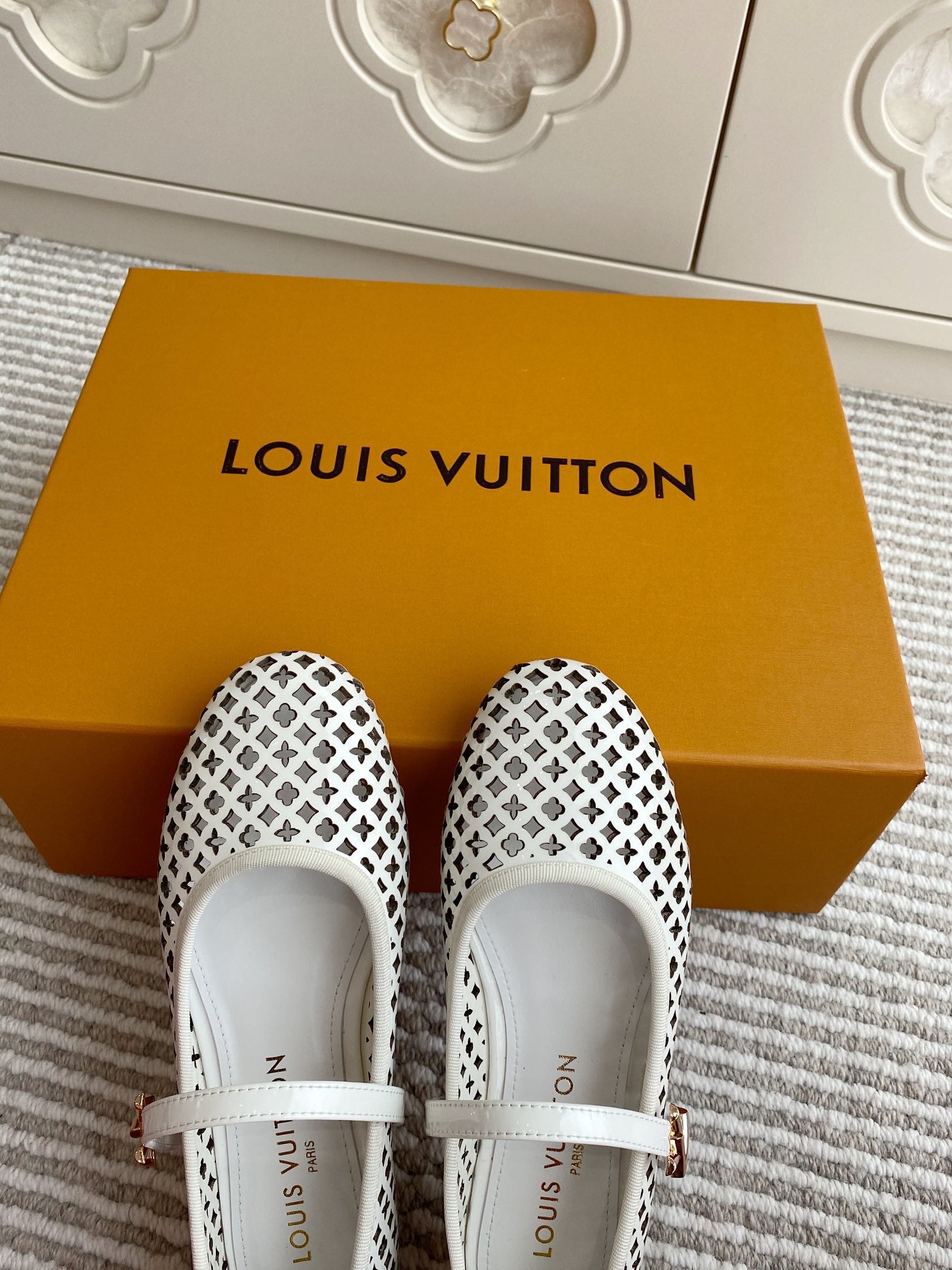 Louis Vuitton logo-pattern flats with white strap, soles facing camera, pair view