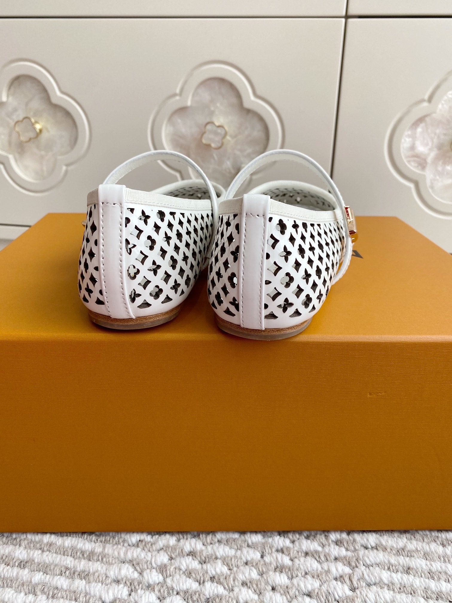 Louis Vuitton logo-pattern flats with white strap, rear view of pair showing heel area