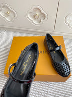 Black patterned flat ballerina shoes with buckle straps, angled close-up view