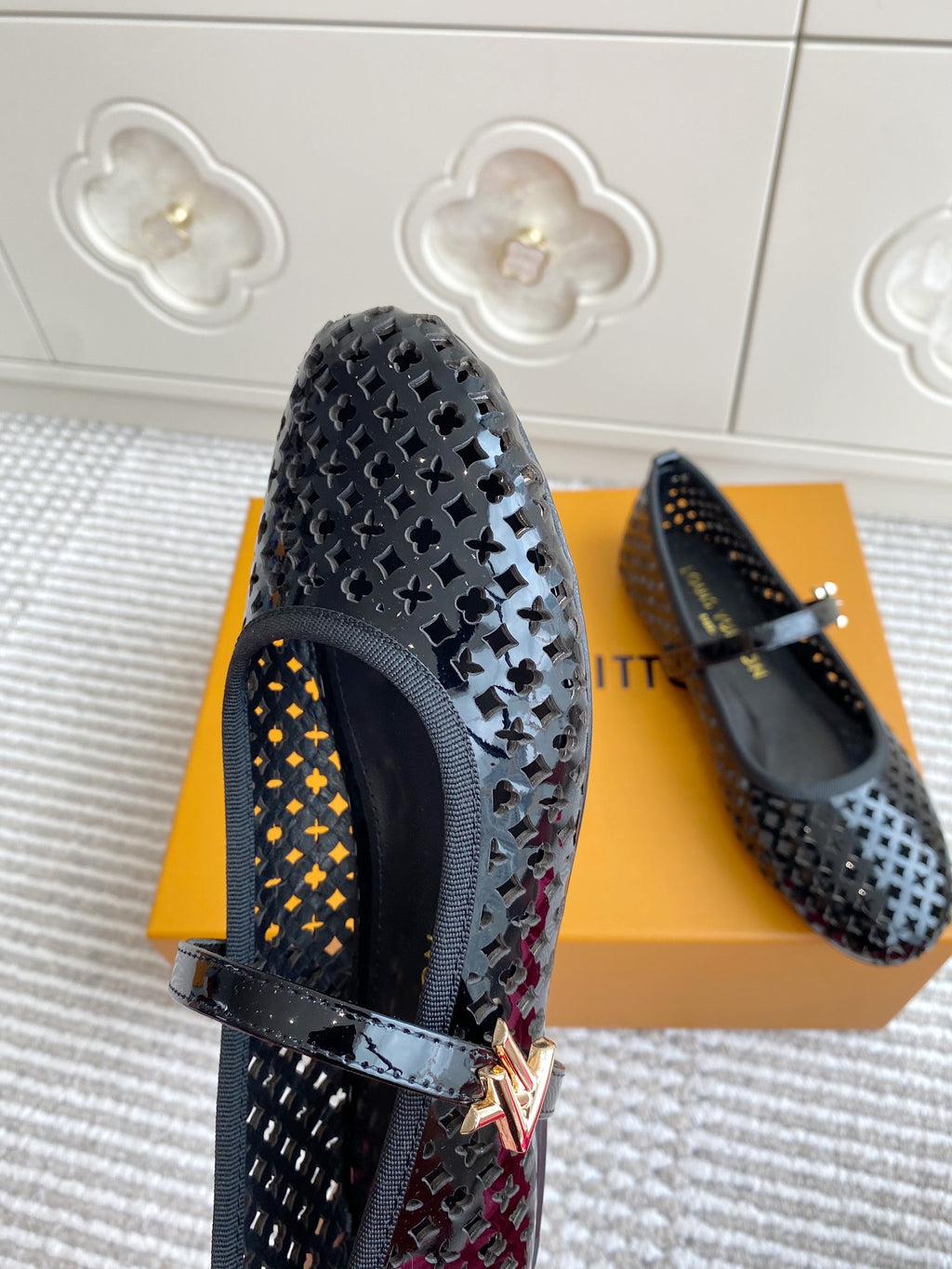 Black patterned flat ballerina shoes with buckle strap, close side view
