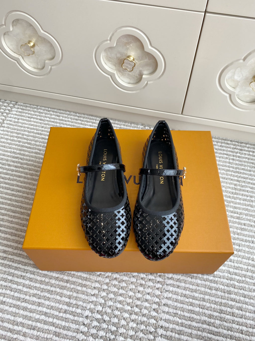 Black patterned flat ballerina shoes with adjustable buckle strap, pair on box