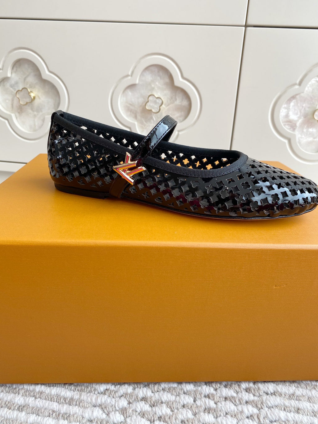 Black and white patterned flat ballerina shoe with buckle strap, side profile