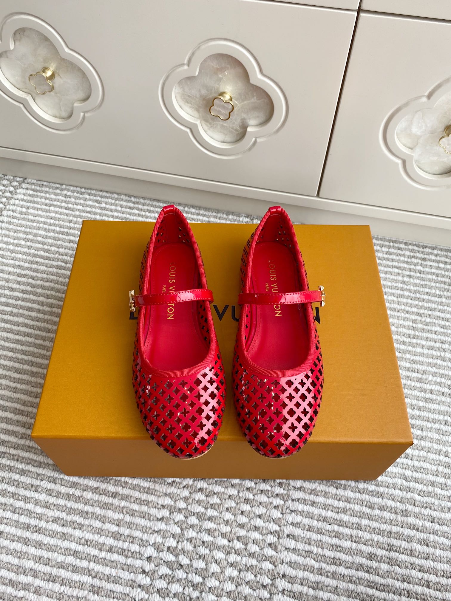 Women's Louis Vuitton flats in red with perforated lattice pattern and strap