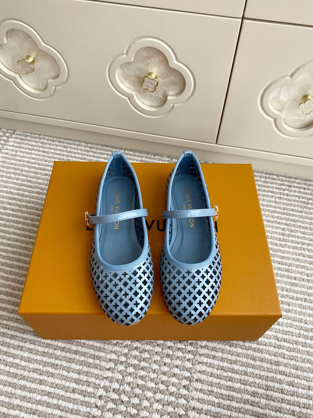 Blue perforated ballet flats with light blue strap and lattice pattern