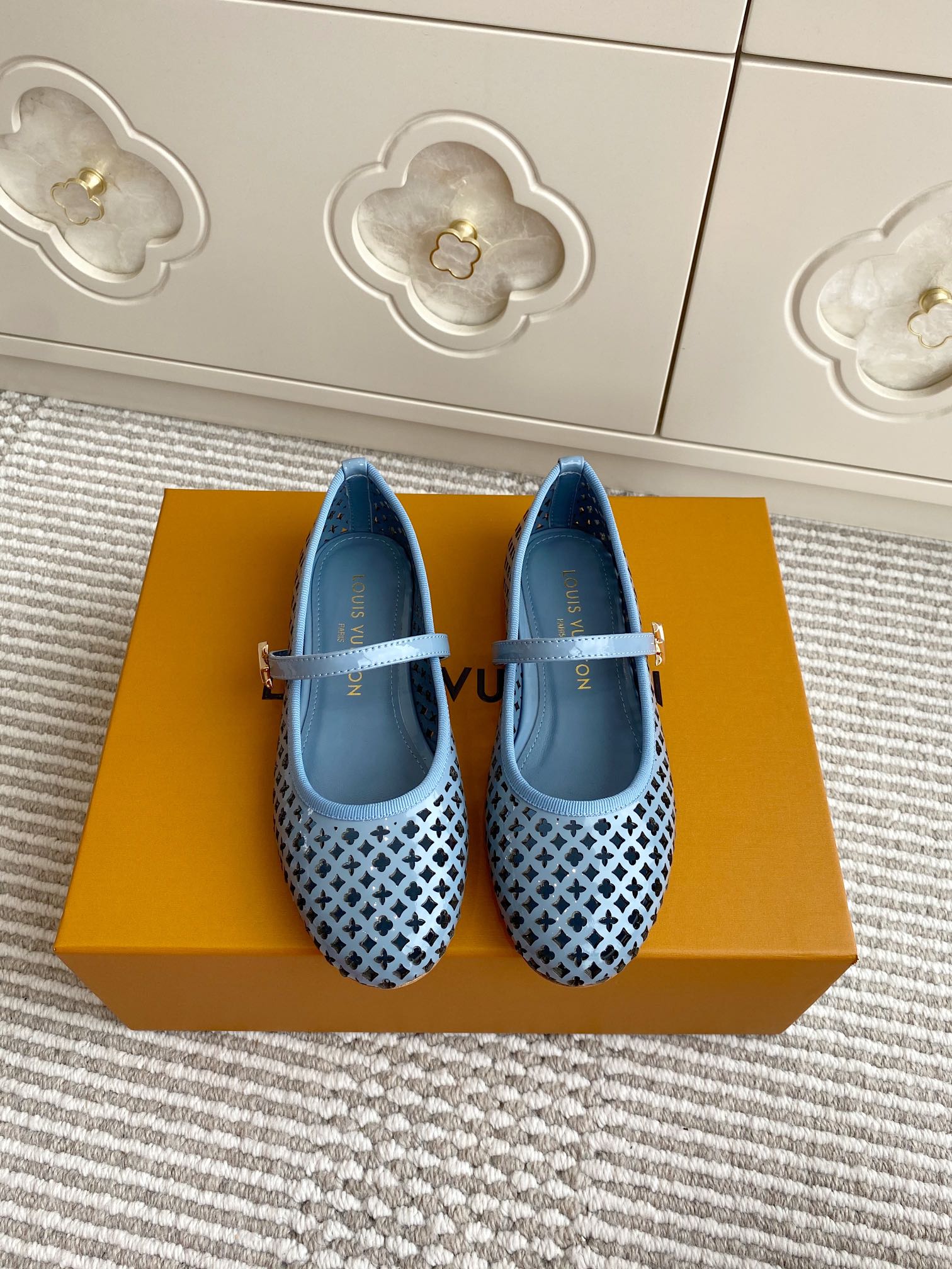 Blue perforated ballet flats with light blue strap and lattice pattern