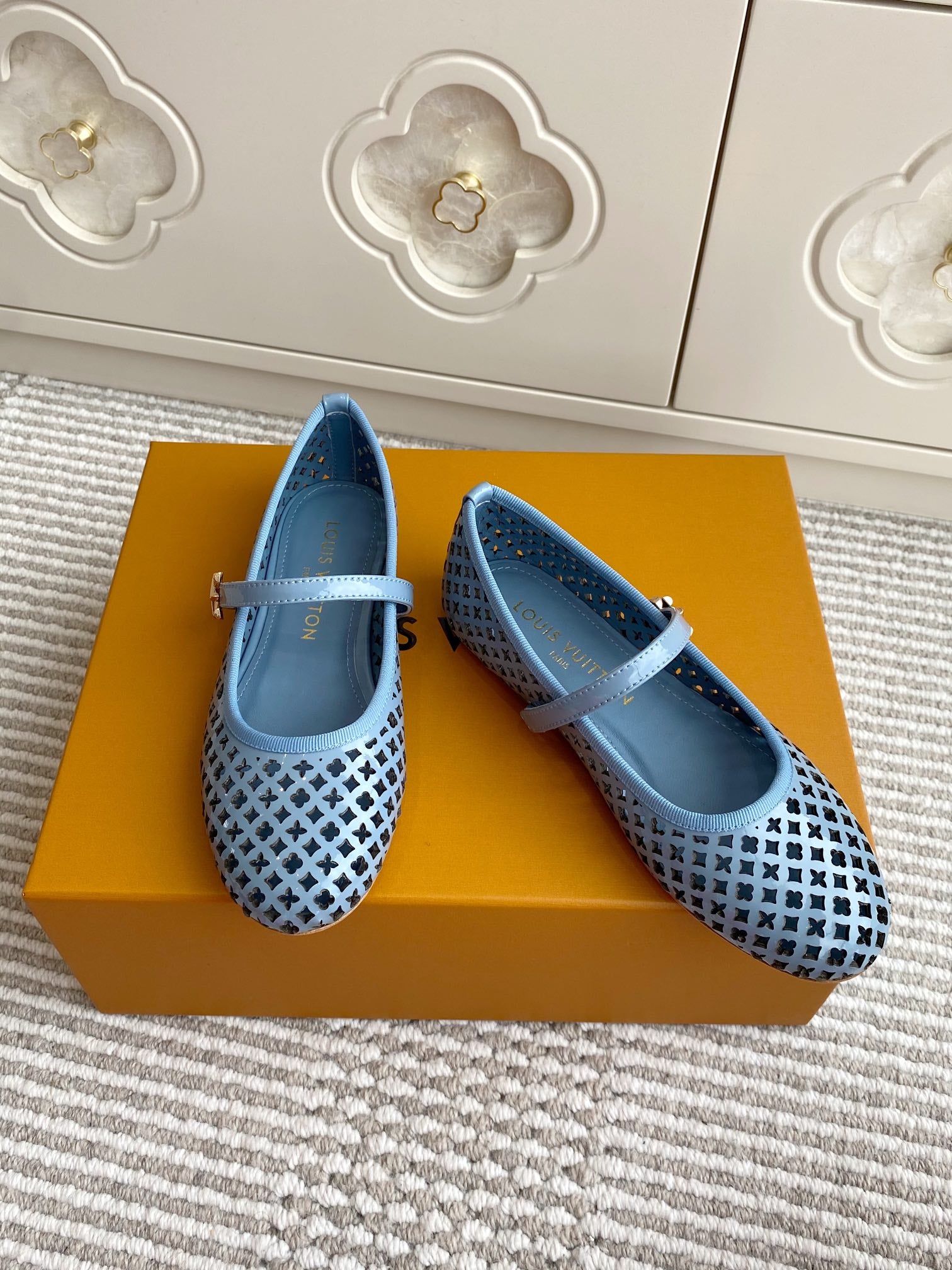 Pair of light blue ballet flats with patterned perforated panels and strap