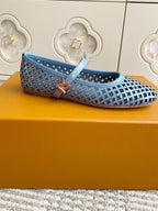 Light blue perforated flats with crosshatch upper, ankle strap, and metal logo accent