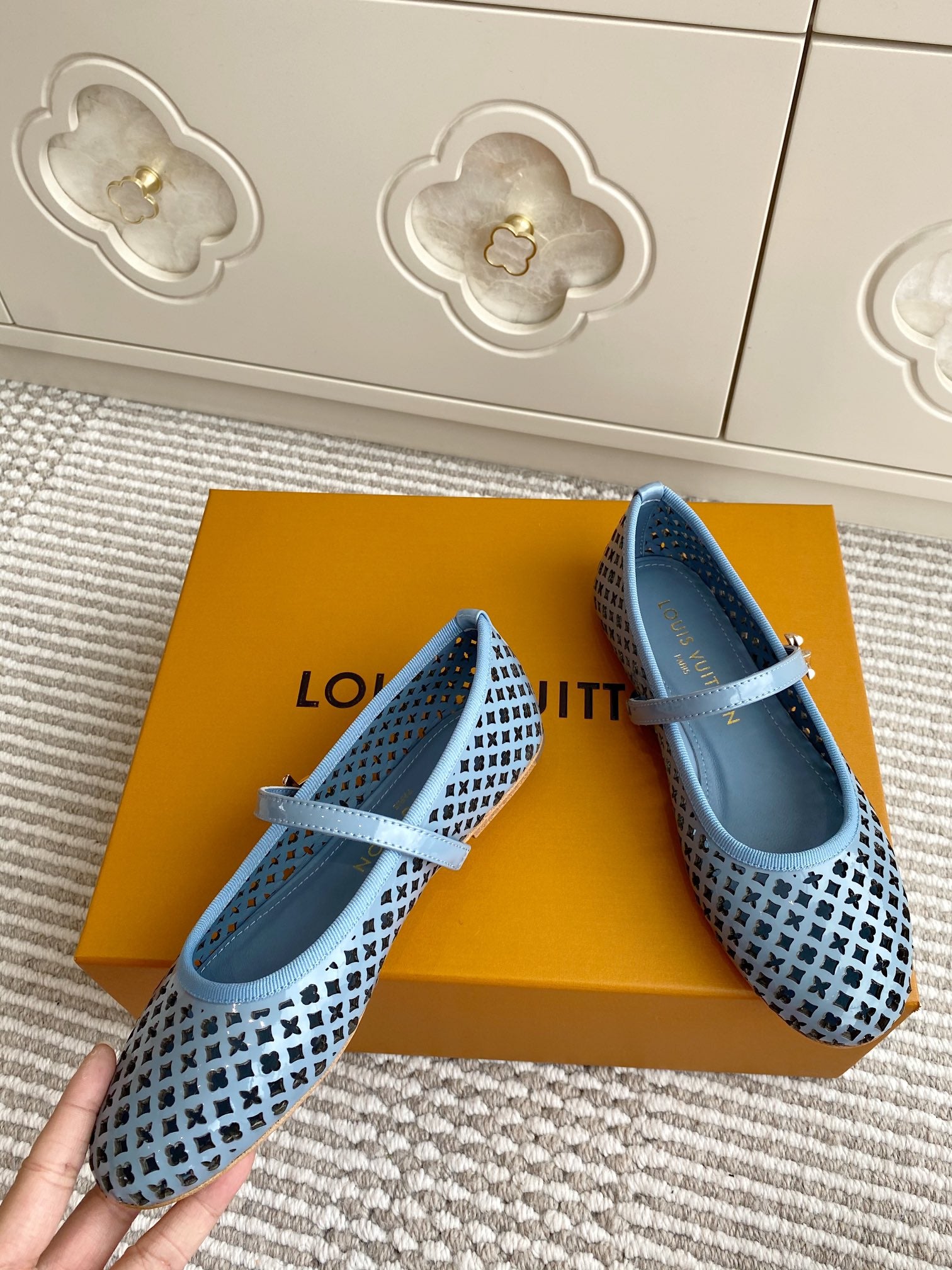 Blue lattice ballet flats with light blue ankle strap on a retail box
