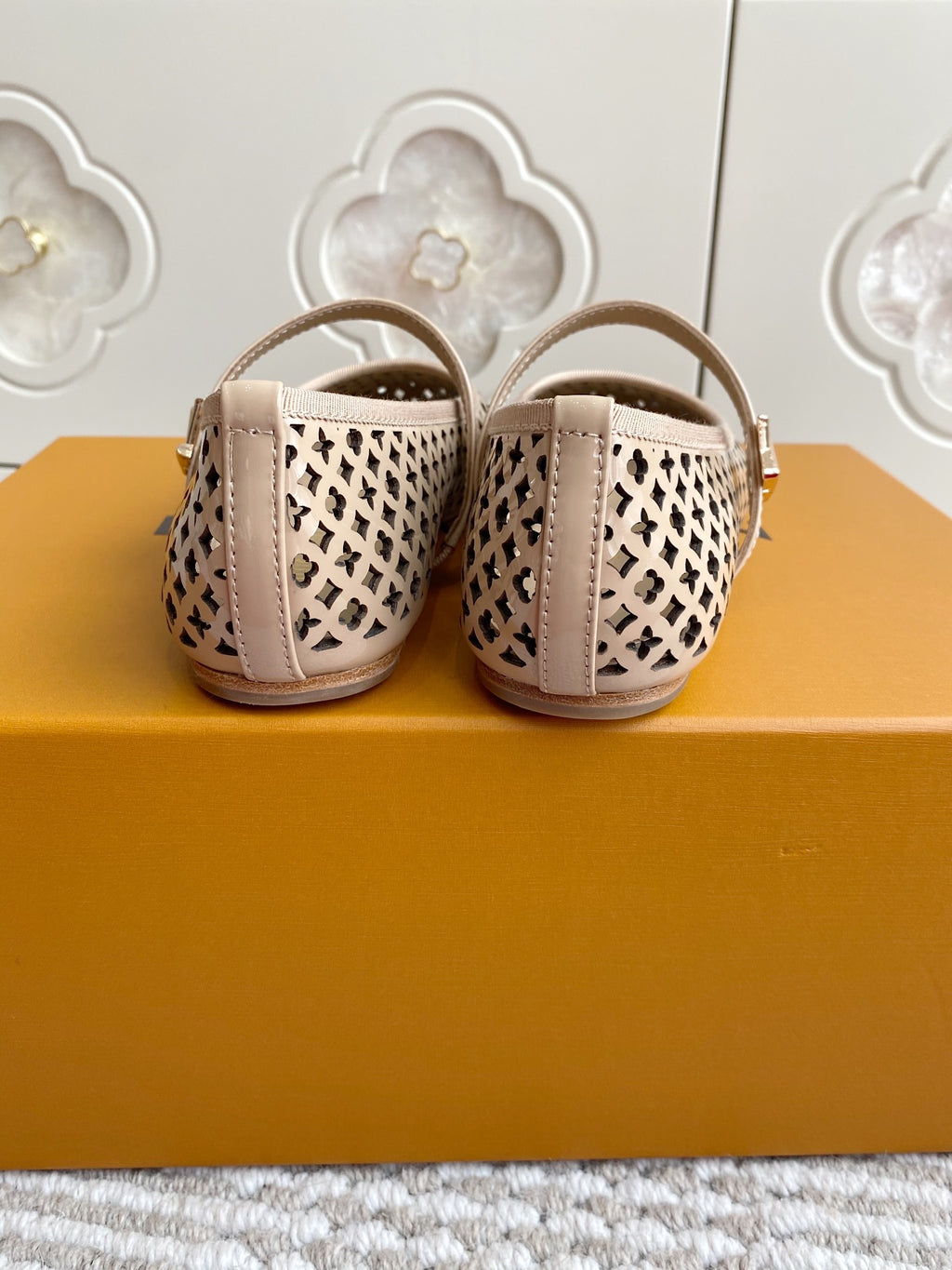 Women’s Louis Vuitton monogram flats rear view, cream patterned canvas, low heel, strap and buckle.