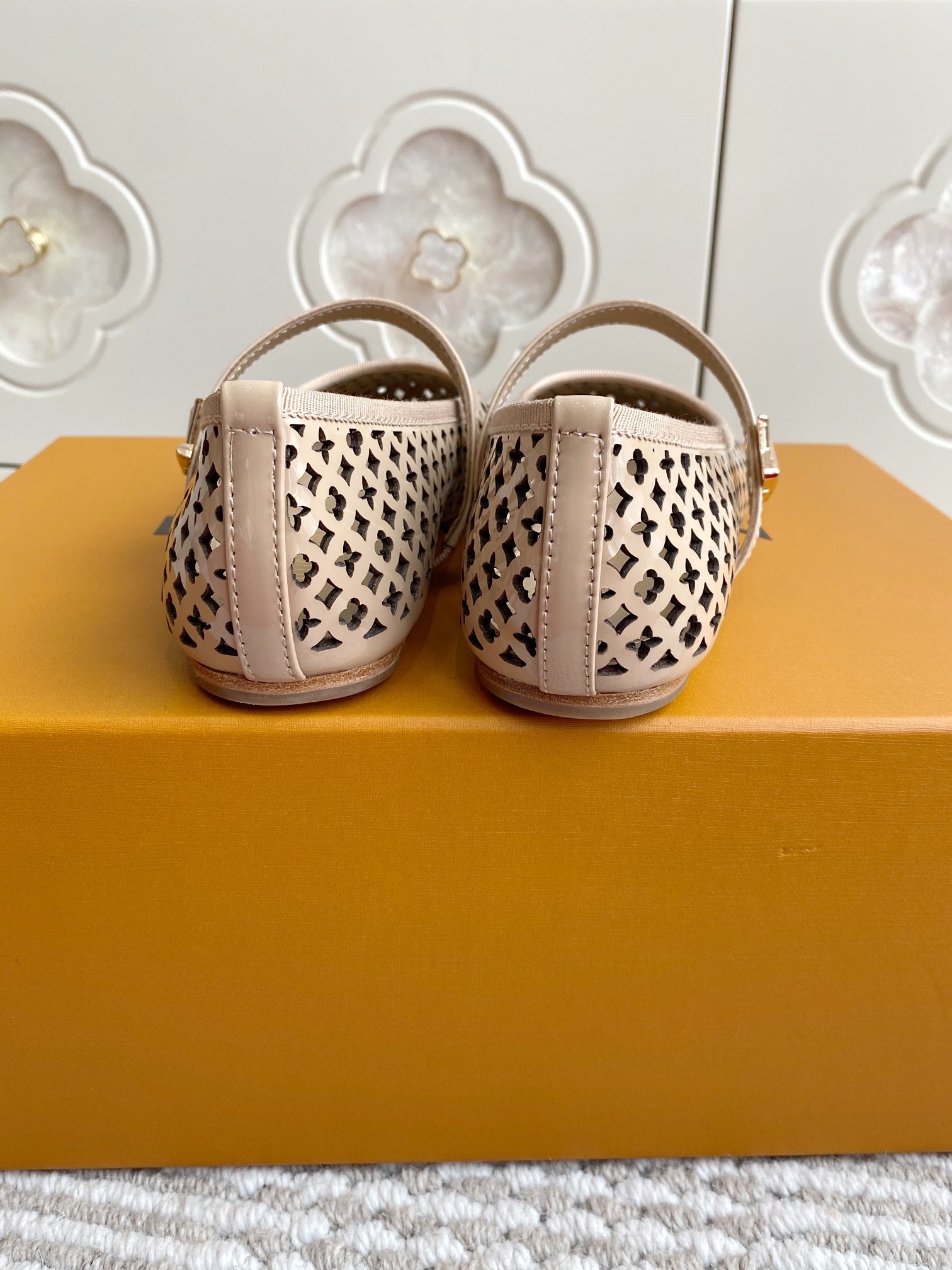 Women’s Louis Vuitton monogram flats rear view, cream patterned canvas, low heel, strap and buckle.