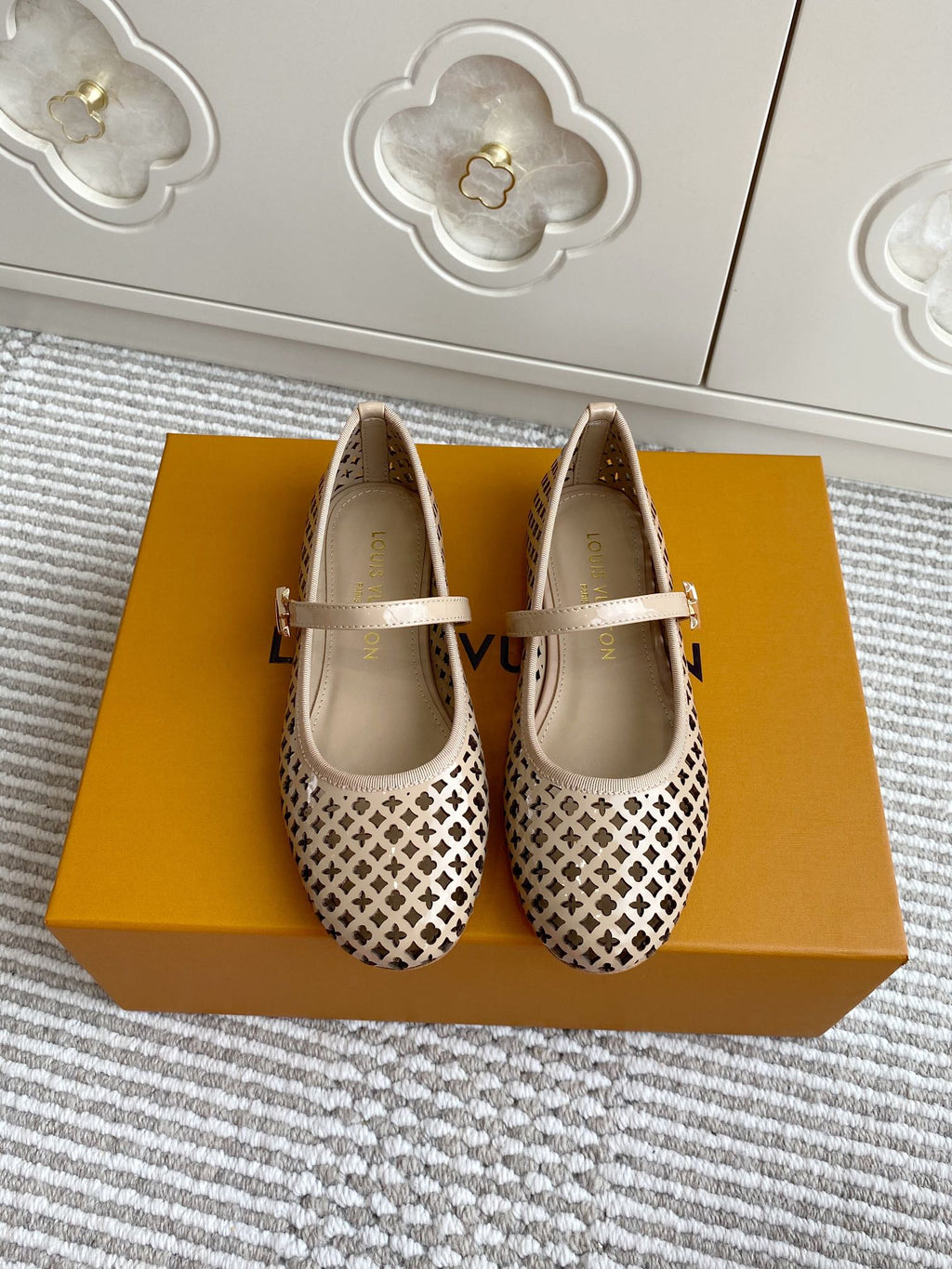 Women’s Louis Vuitton monogram flats, cream leather, perforated pattern, white strap with buckle.