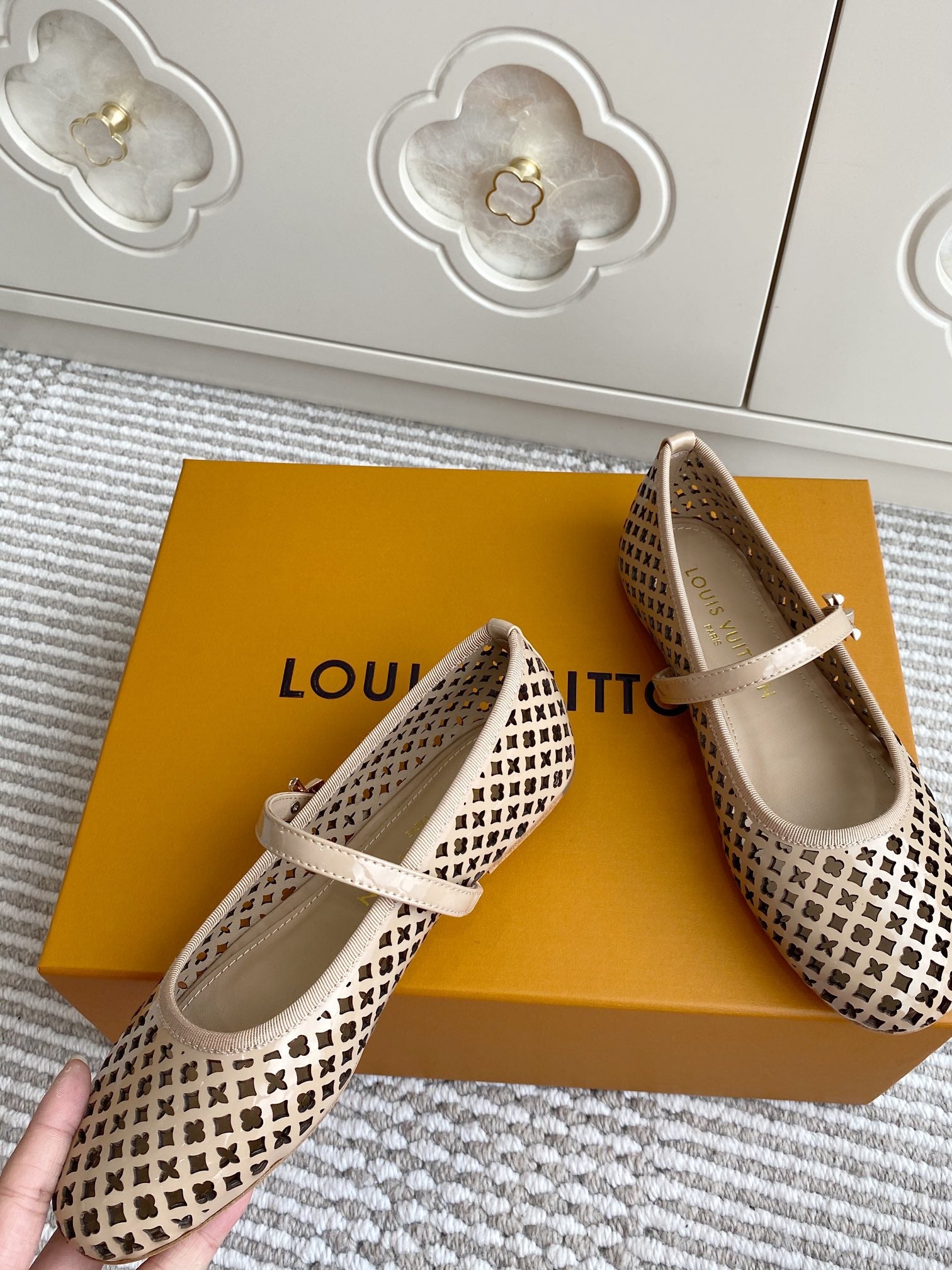 Women’s Louis Vuitton monogram flats, cream leather with lattice pattern, bow-adjacent strap detail.