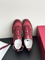 Pair of dark red lace-up sneakers with green side stripes and cream rubber sole