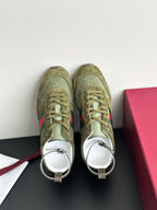 Olive Gucci ladies sneakers with green laces, white lining, and strap detail at collar