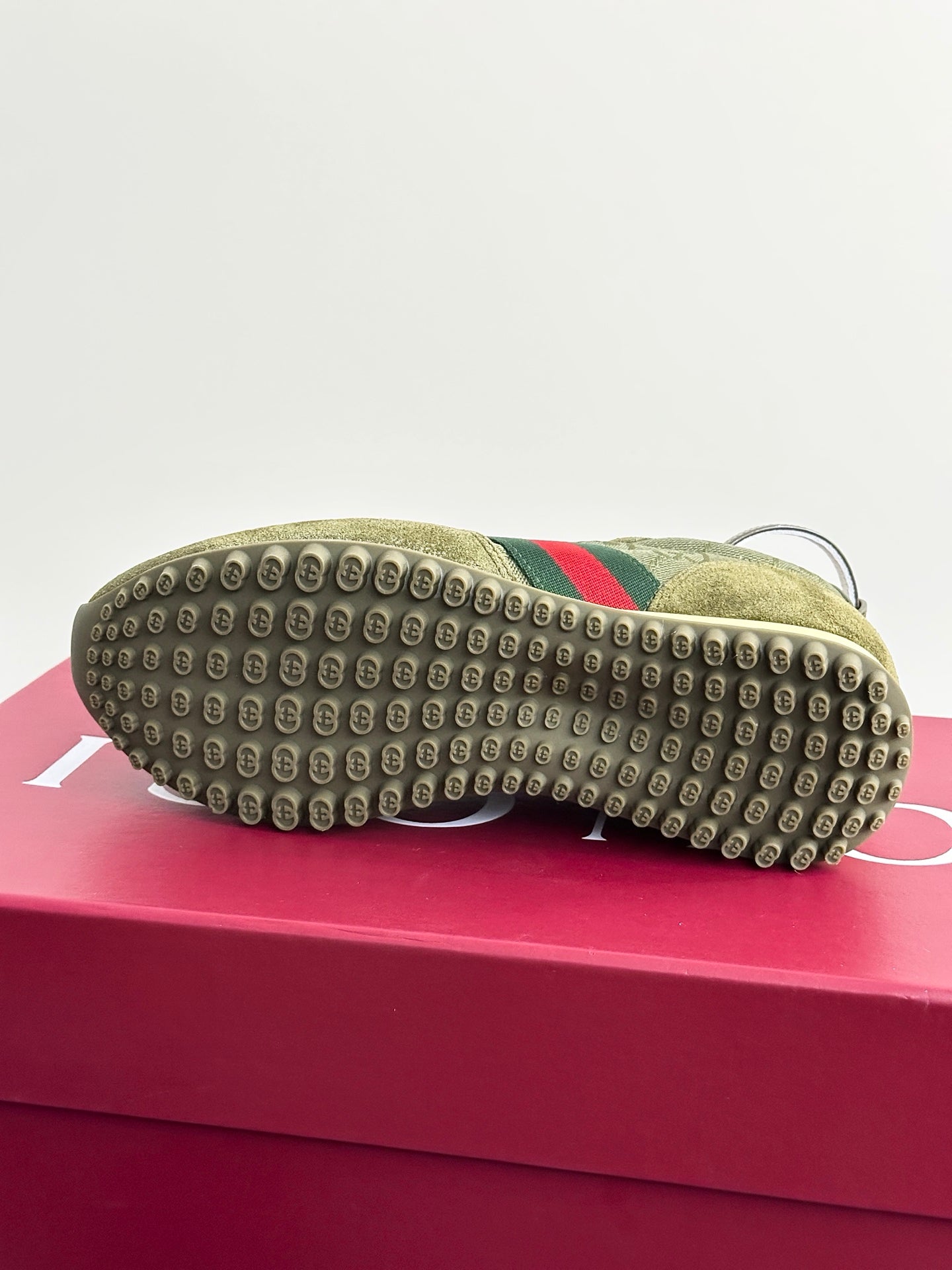Olive suede Gucci ladies sneakers outsole view with studded rubber tread and cream edge