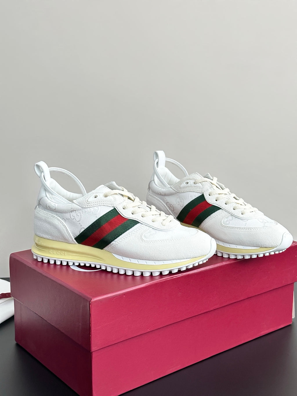 Gucci white sneakers on box with green-red stripe and yellow rubber sole
