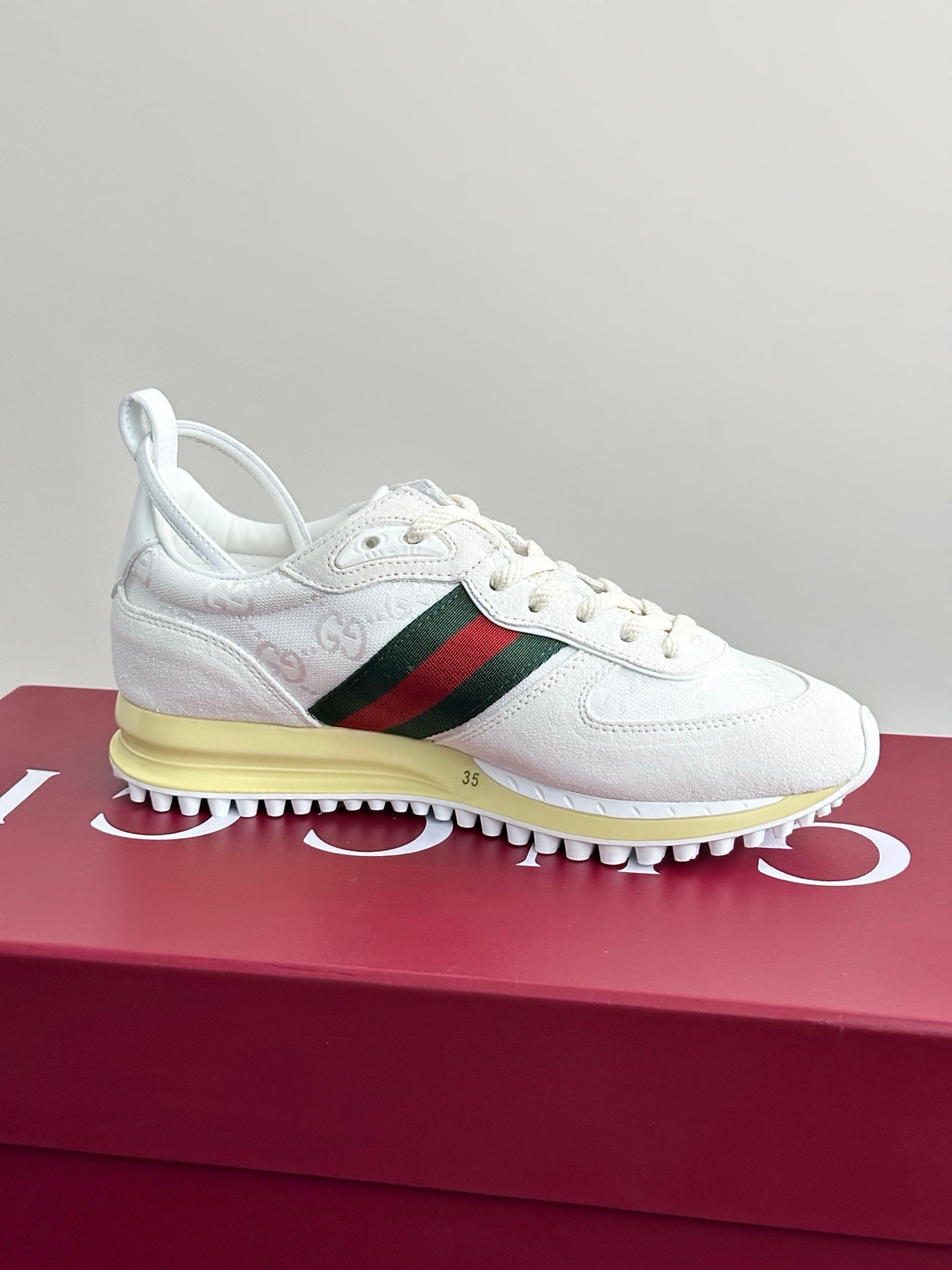 Gucci white lace-up sneakers on box, green-red stripe and yellow midsole