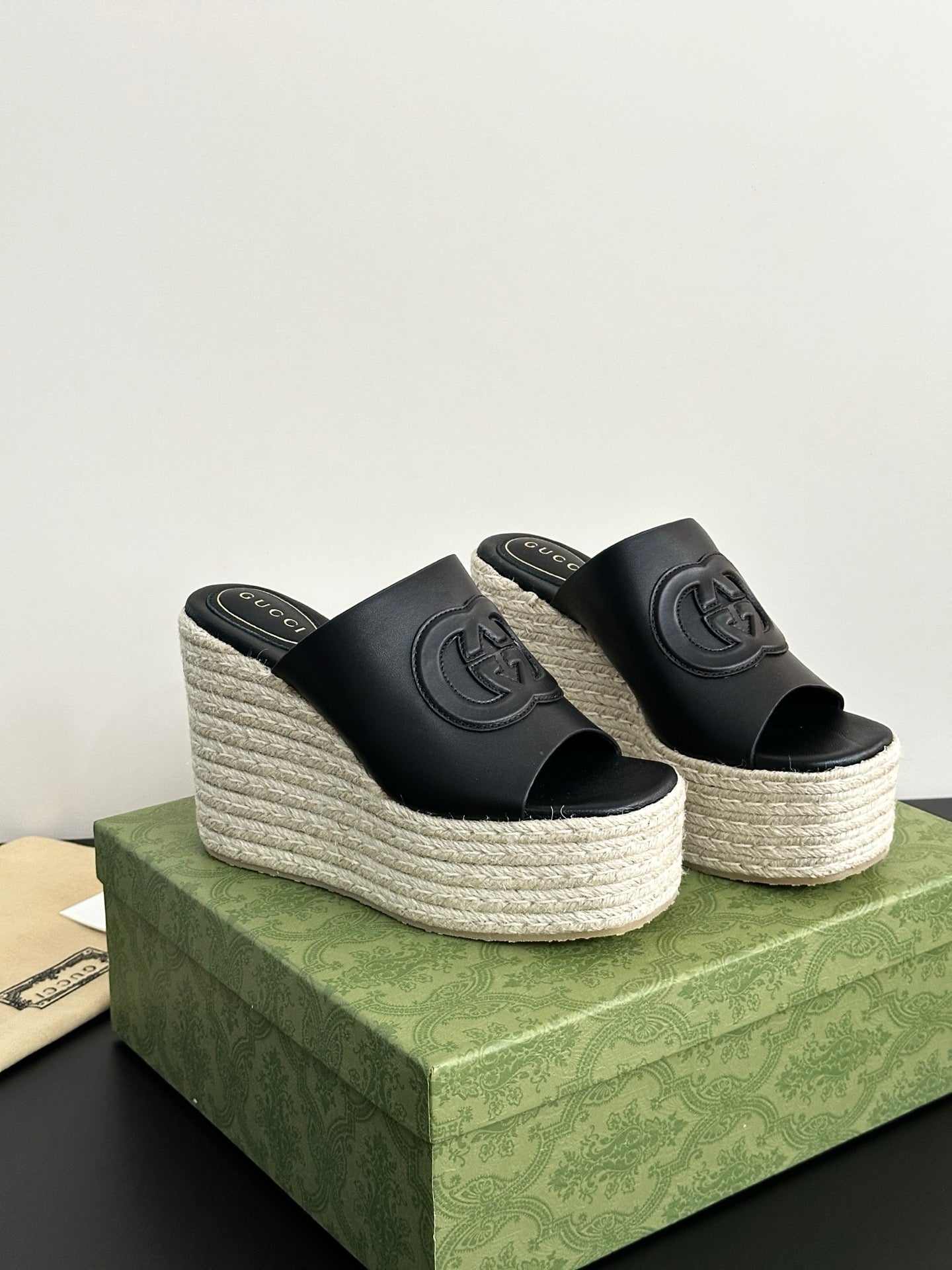 Gucci ladies black platform slide sandals with GG logo, showing both wedge sides